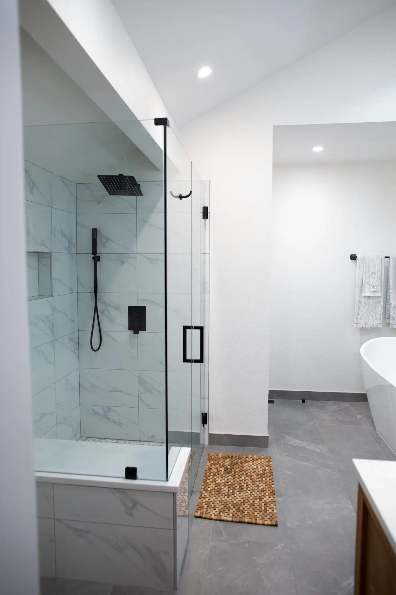 Large marble shower with bench in an Arapahoe bathroom remodel