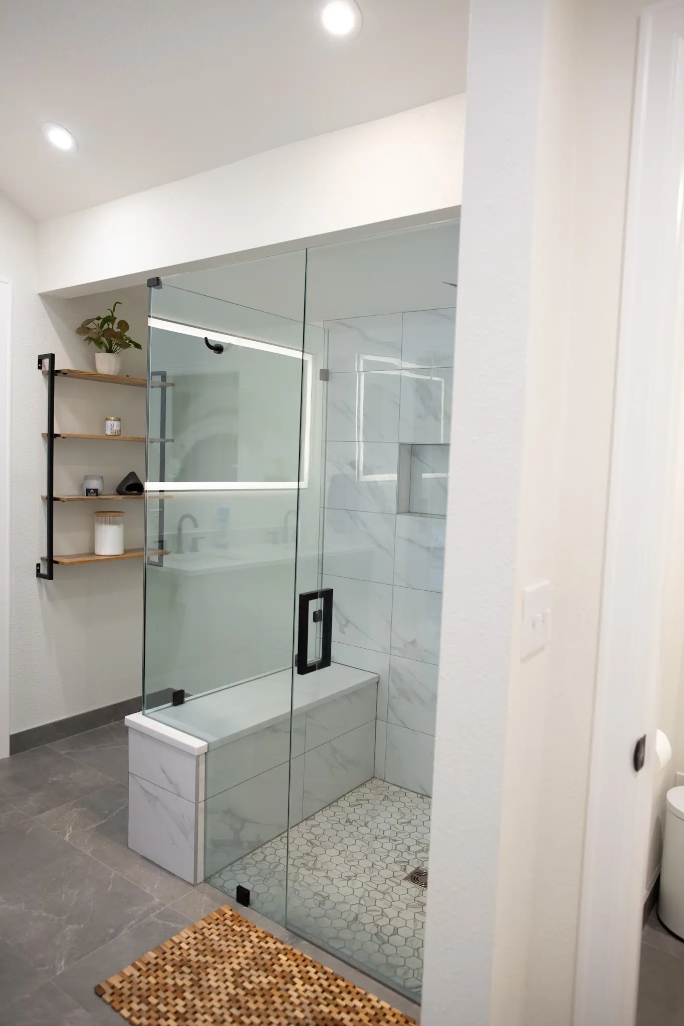 Arapahoe bathroom remodel with marble surfaces, a freestanding tub, double vanity, and large shower