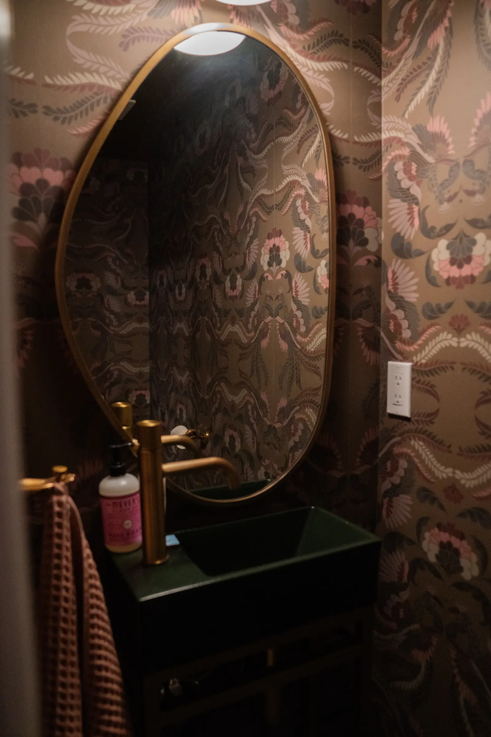 Finished powder room with wallpaper and green sink